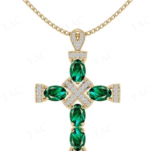 May include: A gold chain necklace with a green emerald and diamond cross pendant.