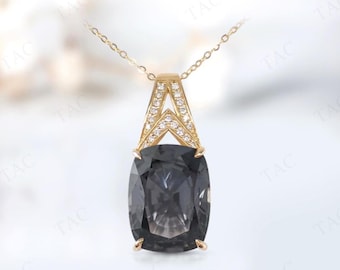 May include: A gold pendant necklace featuring a large, rectangular, smoky gray gemstone. The pendant has a decorative gold bail with small, clear accent stones. The necklace chain is delicate gold.
