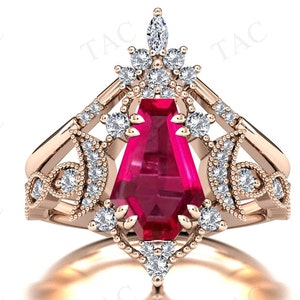 May include: Rose gold ring set featuring a large, rectangular, ruby-red gemstone. The ring is adorned with numerous small, clear gemstones and intricate filigree detailing. The design includes a crown-like top and a delicate band.