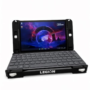 Könnte beinhalten: Schwarzer Lenovo Legion Laptop mit einem Bildschirm, der eine farbenfrohe Grafik anzeigt. Der Laptop hat eine eingebaute Tastatur und ist in einen schwarzen Rahmen eingefasst. Das Wort "LEGION" ist unten aufgedruckt.