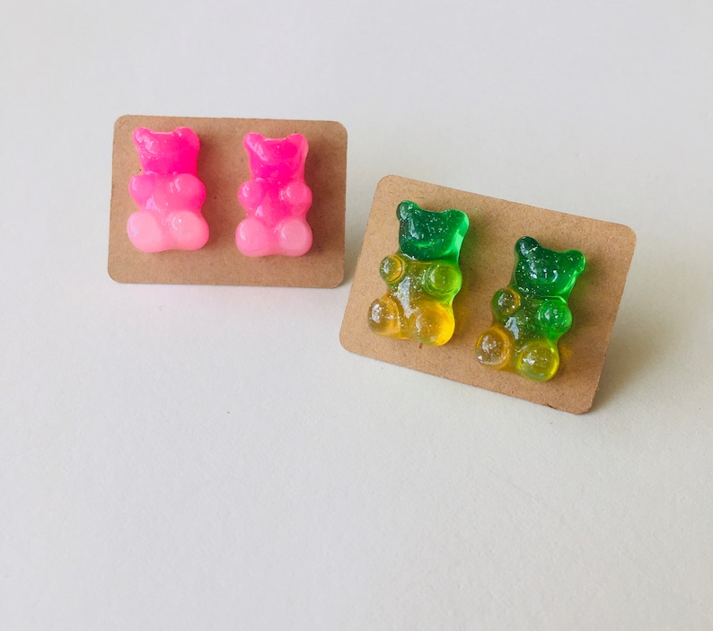 May include: Two pairs of gummy bear earrings. One pair is pink and the other is green and yellow.