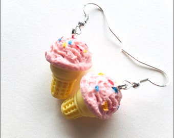 May include: A pair of pink ice cream cone earrings with colorful sprinkles. The earrings are made of polymer clay and have silver hooks.