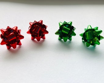 May include: Four small, decorative bows made of shiny metal. Two are red and two are green.