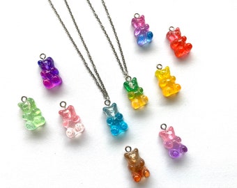 May include: A silver chain necklace with a variety of gummy bear charms in different colors, including green, blue, pink, purple, orange, and yellow.