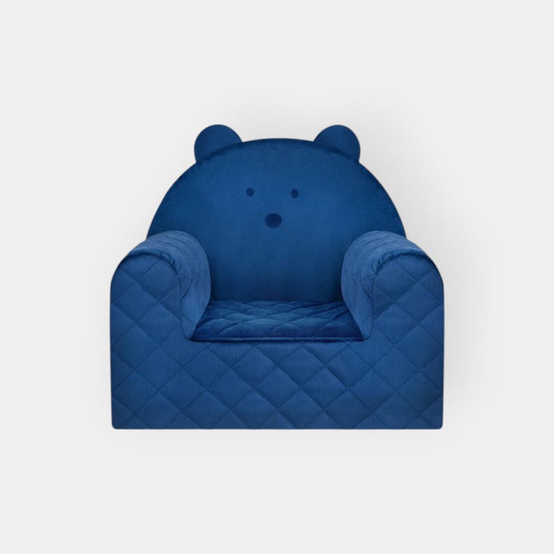 May include: A blue quilted armchair with bear ears and a bear face on the back. The chair is designed for children.
