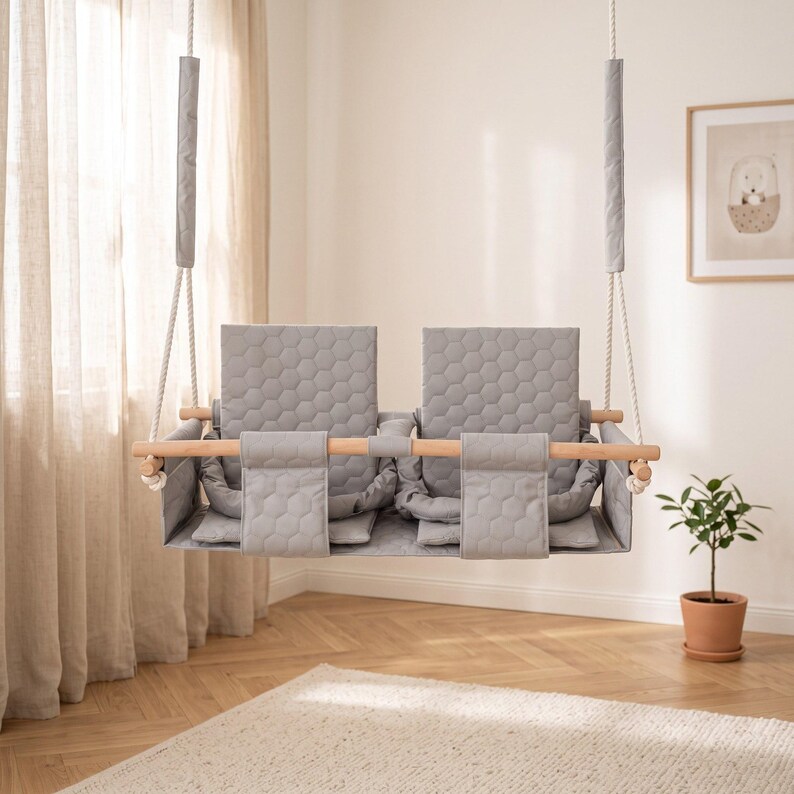 Waterproof twin swing in light grey, double seat with safety belts - styled in a bright nursery