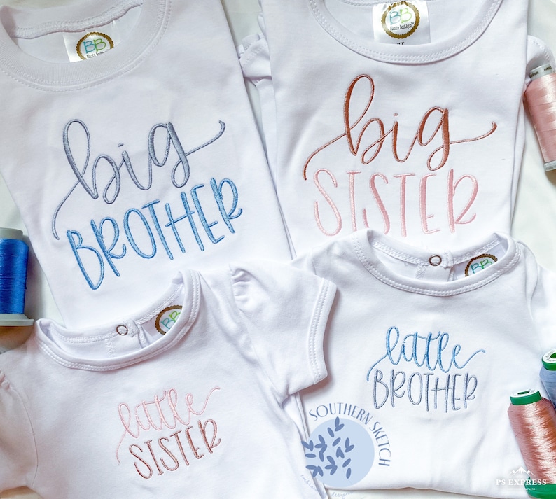 May include: Four white t-shirts with embroidered text. Two shirts say "big brother" and "big sister" in blue and pink script. The other two shirts say "little sister" and "little brother" in pink and blue script.