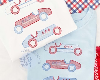 May include: Five embroidered race car designs on two different fabric backgrounds. The cars are red and blue with white stars and white wheels. The fabric backgrounds are white and light blue.
