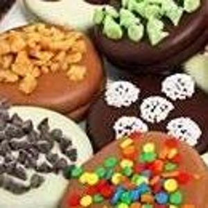 Puede incluir: Primer plano de varias rosquillas decoradas. Una rosquilla est&aacute; cubierta con nueces picadas, otra con trozos de menta verde y una tercera con chispas de colores. Se ven otras rosquillas con chispas de chocolate y chispas blancas.