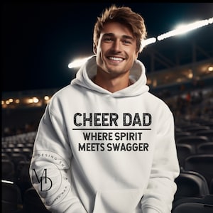 May include: White hooded sweatshirt with the text "Cheer Dad Where Spirit Meets Swagger" printed in black.