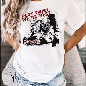 May include: White t-shirt with a black and white illustration of a football player running with the ball. The text "Plot Twist We Da Best" is above the player and "Hornets" is below the player. The text is in red.