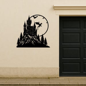 Pode incluir: Arte de parede em metal preto que retrata um castelo numa montanha, com um drag&atilde;o e um p&aacute;ssaro voando em frente a um fundo circular. O castelo tem v&aacute;rias torres e &eacute; rodeado por &aacute;rvores. A arte &eacute; montada numa parede bege.