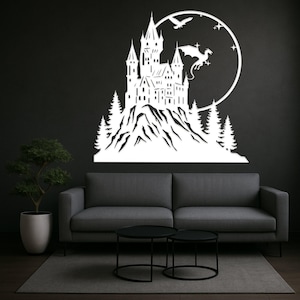 Pode incluir: Arte de parede em metal branco que retrata um castelo numa montanha, com um drag&atilde;o, p&aacute;ssaros e estrelas contra um fundo circular. O castelo apresenta m&uacute;ltiplas torres e &eacute; rodeado por &aacute;rvores estilizadas. A obra de arte &eacute; montada numa parede escura acima de um sof&aacute; cinzento.