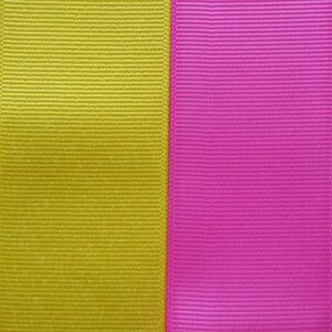 Pode incluir: Um close-up de duas fitas de tecido, uma amarela e outra rosa, costuradas lado a lado.