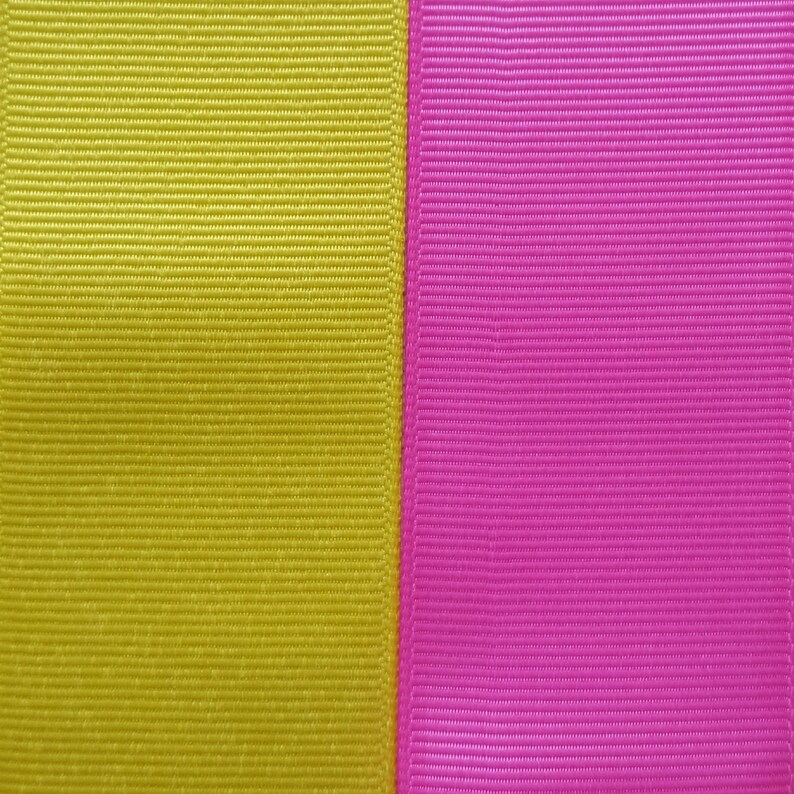 Pode incluir: Um close-up de duas fitas de tecido, uma amarela e outra rosa, costuradas lado a lado.