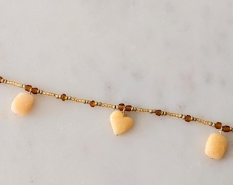 Choker-style necklace in gold and amber colours with 3 charms.