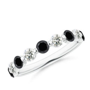 Pode incluir: Um delicado anel de banda de prata com diamantes redondos pretos e brancos alternados.