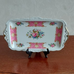 Plato para tarta de Royal Albert Bone China Lady Carlyle de porcelana blanca decorado con flores rosas de color rosa y con un hermoso borde dorado.