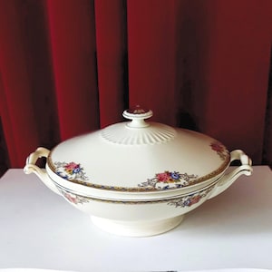 Covered dishes or tureens marked Ivory, decorated with red and blue flowers and gold lines and knobs on the lid.