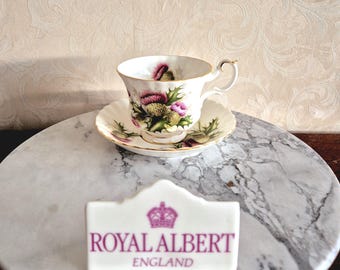 Tasse et soucoupe pour homme de Royal Albert Bone China Angleterre « Highland Thistle » décorées de motifs de Noël et d'un chardon violet, années 1960.
