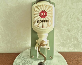 Wall-mounted coffee grinder with bean container made for Douwe Egberts, with the imprint "D-E Koffie", vintage 1960s, works perfectly and is in good condition.