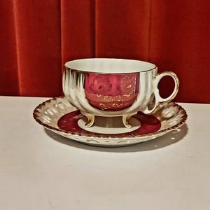 Tazza e piattino in porcellana Versailles, vintage anni &#39;50. Il colore è bordeaux con riflessi madreperla e decorazioni dorate.