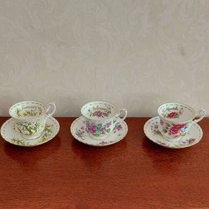 Men's sets of cups and saucers from Royal Albert Flower of the month January to December decorated with flowers and gold lines.