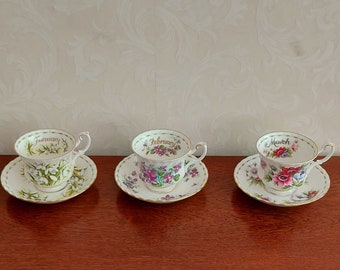 Men's sets of cups and saucers from Royal Albert Flower of the month, January to December, decorated with flowers and gold lines.