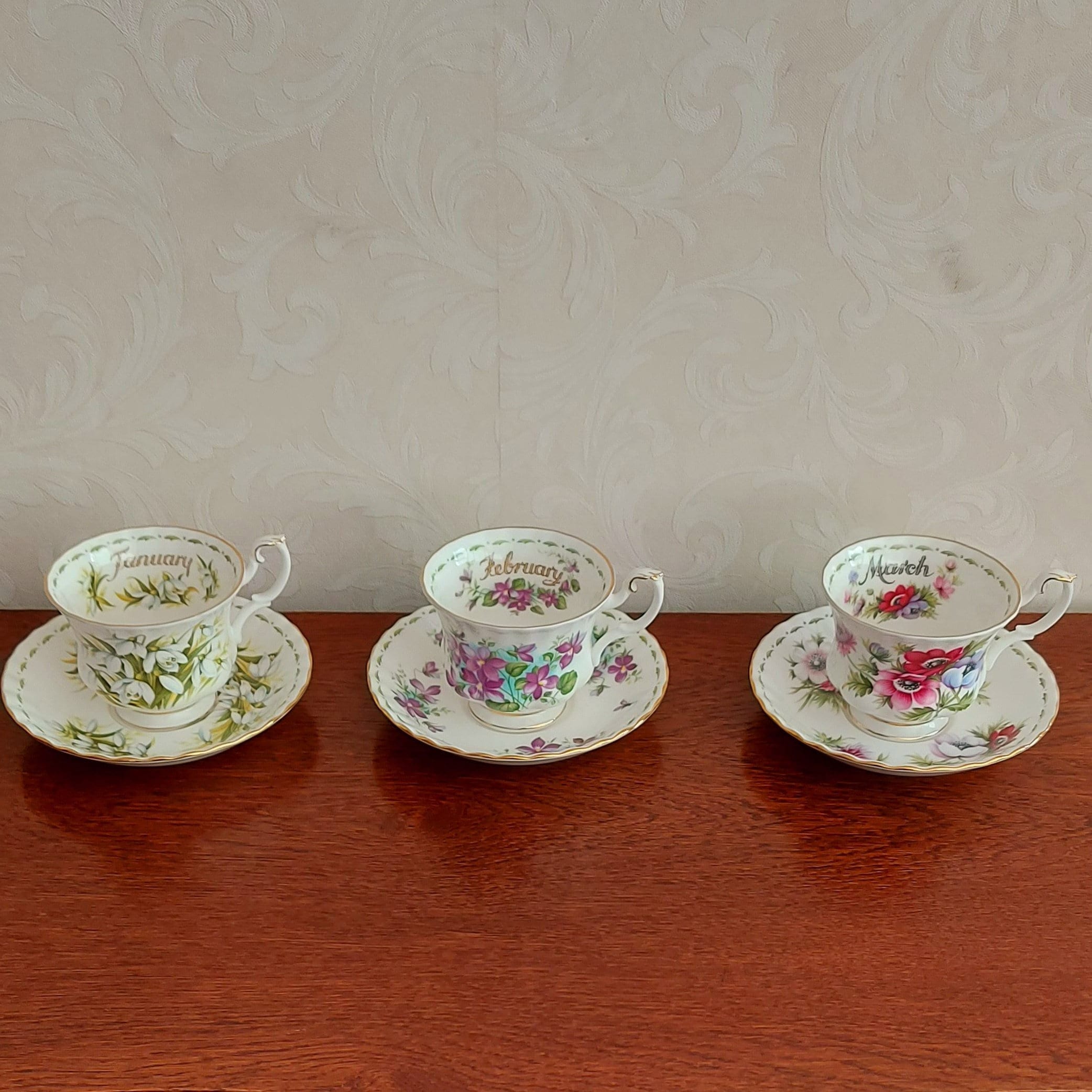 Men's sets of cups and saucers from Royal Albert Flower of the month January to December decorated with flowers and gold lines.