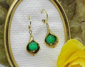 Gold-colored calyx earrings with a green Polaris pearl