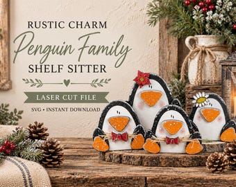 Op de afbeelding: Een set van drie houten pinguïnfiguren met zwart-witte lichamen, oranje snavels en oranje voeten. Twee pinguïns dragen rode strikjes en één heeft een rode kerststerbloem. De tekst luidt: RUSTIC CHARM Penguin Family SHELF SITTER.