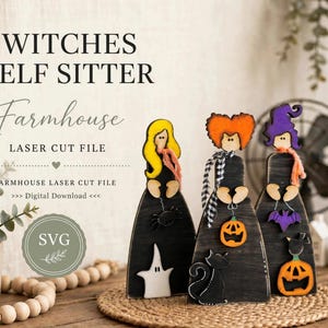 Può includere: Tre statuette di streghe in legno con abiti neri, ognuna delle quali tiene in mano un'icona di Halloween diversa, tra cui un ragno, una zucca e un pipistrello. Le figure hanno capelli gialli, arancioni e viola, con un fantasma bianco.