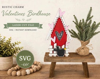 May include: A red and white wooden birdhouse decoration featuring pink heart cutouts, a heart-shaped window, and a black bird silhouette. The text reads RUSTIC CHARM Valentines Birdhouse LASER CUT FILE SVG INSTANT DOWNLOAD.