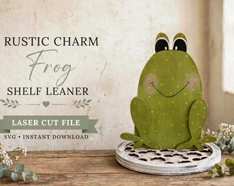 Peut inclure: Une figurine de grenouille verte en bois avec des yeux noirs et des joues roses, ornée de pois. Le texte indique : RUSTIC CHARM Frog SHELF LEANER LASER CUT FILE SVG INSTANT DOWNLOAD. La grenouille repose sur une base circulaire blanche ajourée.