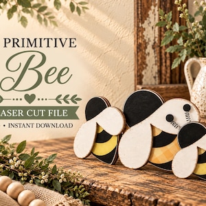 Puede incluir: Tres recortes de madera con forma de abeja con detalles pintados en negro, amarillo y blanco. El texto PRIMITIVE Bee LASER CUT FILE SVG INSTANT DOWNLOAD aparece en fuente negra y verde sobre las figuras de abejas en un fondo claro.