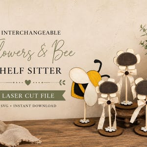 Puede incluir: Un conjunto de decoración de madera cortada con láser que incluye una abeja amarilla y negra y tres letreros con forma de flor con centros oscuros, pétalos claros y lazos de tela color crema sobre tallos finos con bases circulares.