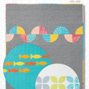 May include: A quilt pattern called "Triplets" by Atkinson Designs. The pattern features a circle with a turquoise background and orange fish, and a white circle with a border of blue, yellow, and green leaves. The text "ATK-185" is in the top right corner.