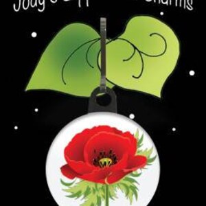 May include: A red poppy flower with green leaves and a white background. The flower is attached to a zipper pull charm with a green leaf design.
