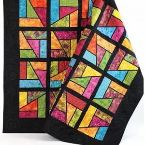 May include: A colorful quilt with a stained glass window design. The quilt is made up of squares of different colors and patterns, including red, orange, yellow, green, blue, and purple. The quilt is edged in black fabric.