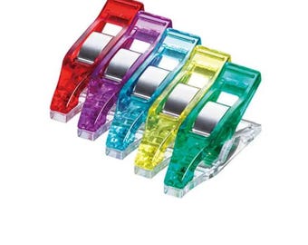 May include: A set of five colorful sewing clips in red, purple, blue, yellow, and green. Each clip has a clear base and a silver metal clasp. These clips are designed for holding fabric layers together.