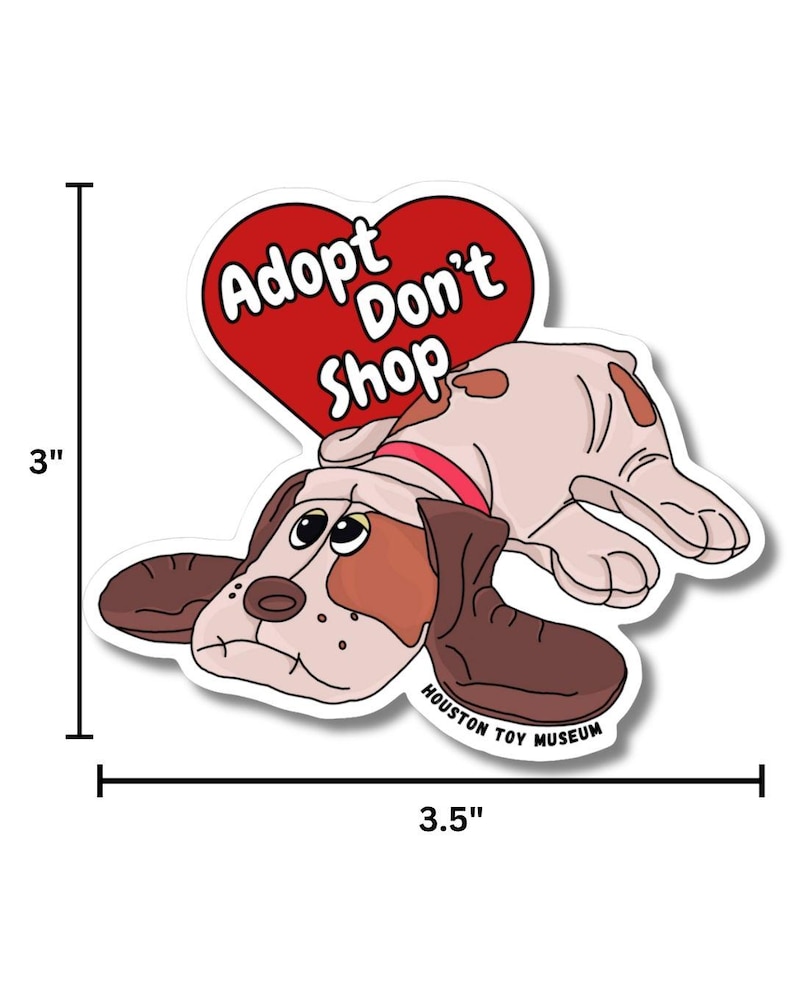 May include: A sticker featuring a cartoon dog with brown and tan fur, wearing a red collar. The dog is lying down with a sad expression. Above the dog is a red heart with the words "Adopt Don't Shop". The sticker is 7.6 cm tall and 8.9 cm wide.