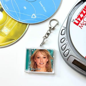 Llavero con estuche de mini CD 'Hit Clips' - Hilary Duff Metamorphasis