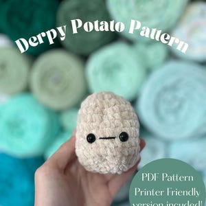 Peut inclure: Une pomme de terre crochetée beige avec des yeux de sécurité en plastique noir et une ligne horizontale cousue pour la bouche. Le texte indique Derpy Potato Pattern et PDF Pattern Printer Friendly version included! Des pelotes de laine vertes en fond.