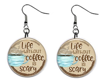 May include: A pair of silver dangle earrings with a round, white-rimmed charm featuring a brown coffee cup with blue stripes and the text "Life without coffee is scary".