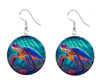 May include: A pair of earrings featuring a colorful sea turtle swimming in a blue and green ocean scene. The turtle has a blue shell with orange and purple accents. The earrings are round and have silver hooks.