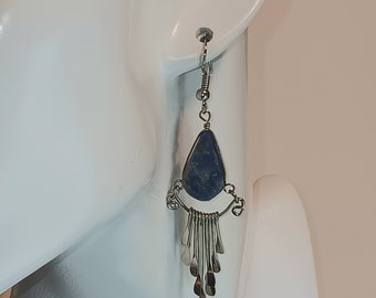 May include: Silver dangle earrings with a blue gemstone pendant and a fringe of silver beads.