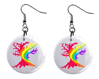 May include: A pair of rainbow tree earrings. The earrings are made of metal and have a round, white disc with a rainbow tree design. The tree is red with a rainbow of colors in the branches.