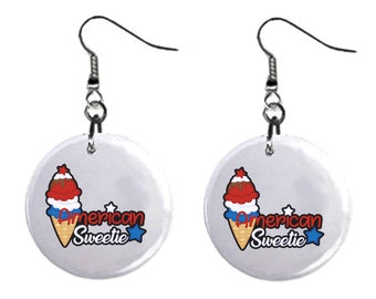 May include: A pair of silver earrings with a white round charm featuring a red, white, and blue ice cream cone with the text "American Sweetie" and a star.