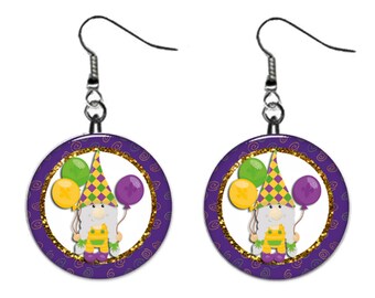 May include: Purple and gold Mardi Gras gnome earrings with a white background and gold glitter. The gnome is wearing a purple and green hat and holding balloons.