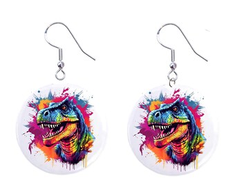 May include: A pair of silver earrings with a round, white ceramic pendant featuring a colorful, abstract dinosaur head with a splash of paint design.